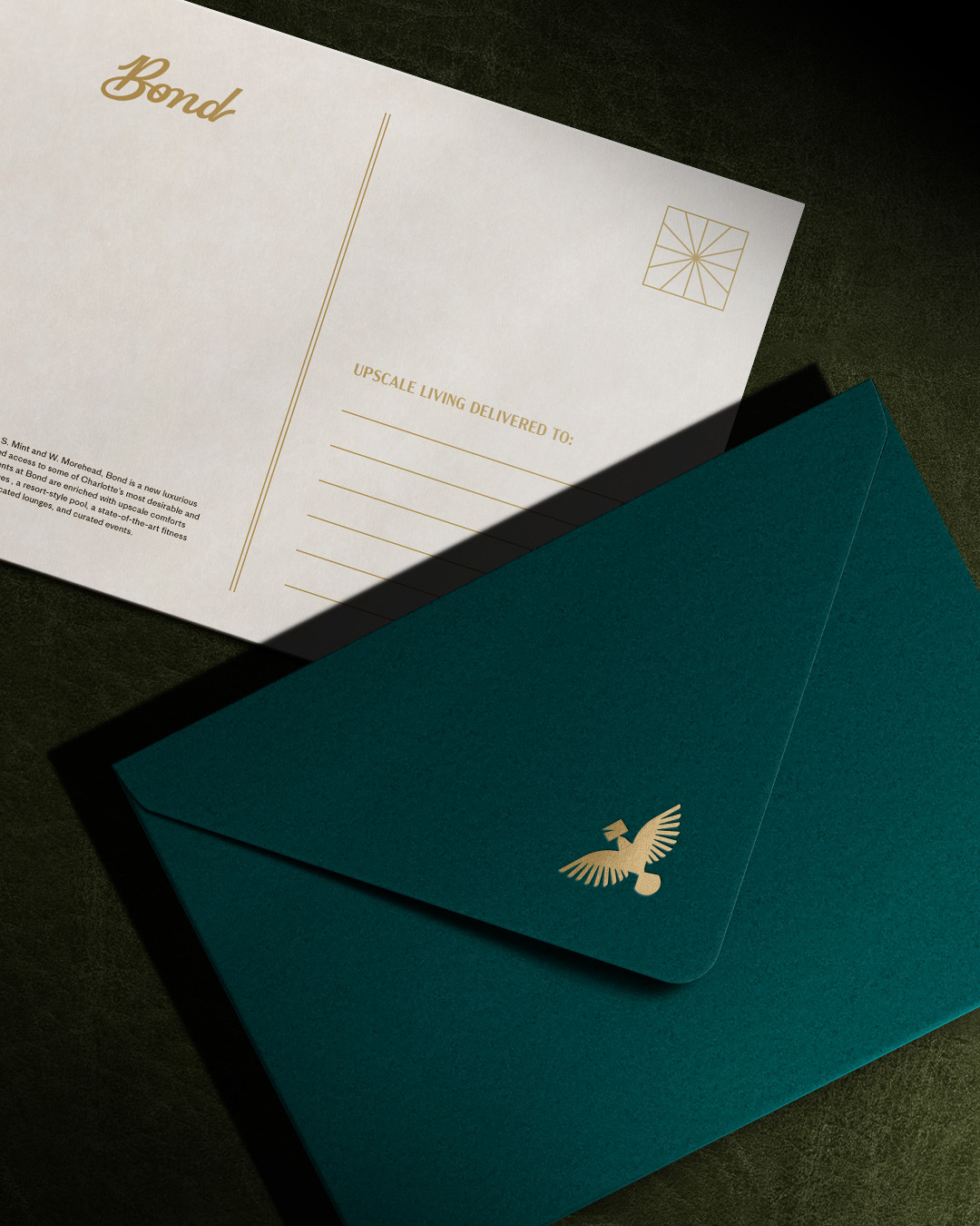 Dark teal envelope and postcard with a gold homing pigion on the flap.